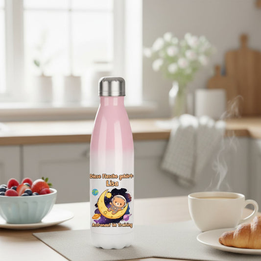 Personalisierte Kinderflasche steht auf einem liebevoll gedeckten Frühstückstisch mit Obst, Croissant und warmer Milch.